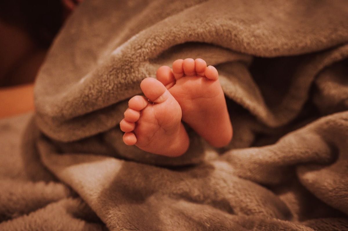 Die Füße eines Neugeborenen in einer weichen Decke